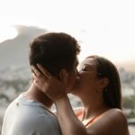 A couple shares a tender kiss during a sunset in Monterrey, Mexico, symbolizing love and intimacy.