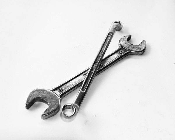 pexels-photo-210881-210881-1 A pair of crossed metal wrenches on a clean white surface.